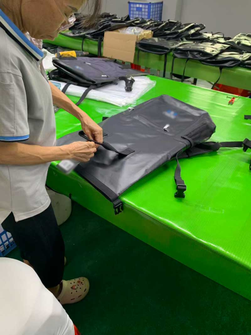 Operator attaching a printed retail hangtag with barcode to a finished bag